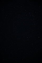 High-resolution vertical astrophotography showing tiny bright stars on an ink-black night sky backdrop, designed for phone wallpapers and astronomical designs © UP
