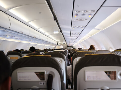 Passengers flying inside airplane cabin during domestic journey
