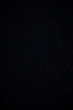 High-resolution vertical astrophotography showing tiny bright stars on an ink-black night sky backdrop, designed for phone wallpapers and astronomical designs