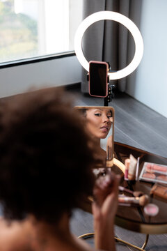 Influencer filming a makeup tutorial with a ring light