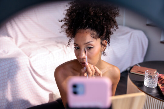 A young woman filming a beauty makeup tutorial