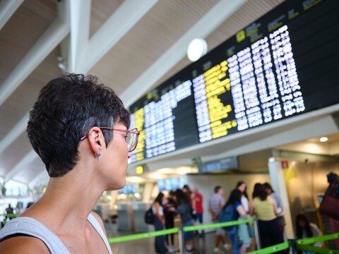 Traveler looking at airport departure arrival board