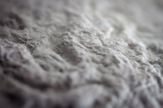 Extreme close up of old gray handmade paper clay with a structure and rough texture. Paper recycling. Selective soft focus, shallow depth of field.