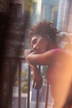 Pensive woman gazing from a city balcony