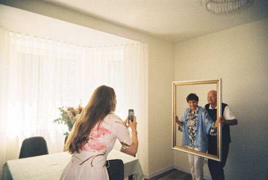 Senior Couple Poses for a Picture To Their Daughter