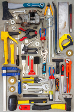 Flat lay of old and new hand tools on concrete background. Large collection of various tools and bits arranged on concrete.