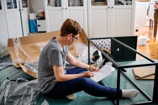 Woman Assembling Flat Pack Furniture at Home