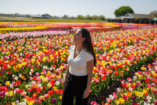 Woman enjoying the scent and breeze in a vibrant tulip field