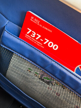 BURBANK, CA, APR 28, 2026: Close-up of a red Boeing 737-700 safety information card tucked into a seatback mesh pocket on Southwest Airlines