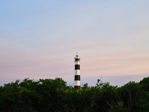 Far d'Artrutx lighthouse showing striped tower at sunset in Menorca
