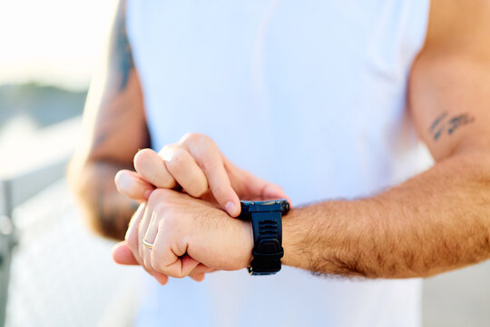 Man monitoring workout progress and health data on a smart watch. Technology supporting active lifestyle and physical fitness