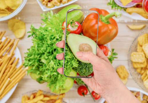 Phone shows greens amid chips, pretzels, fries and a burger
