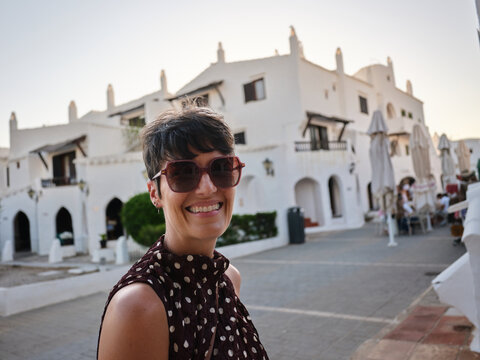 Woman smiling enjoying travel in Binibeca Vell, Menorca, Spain