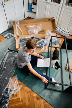 Woman Assembling Flat Pack Furniture at Home