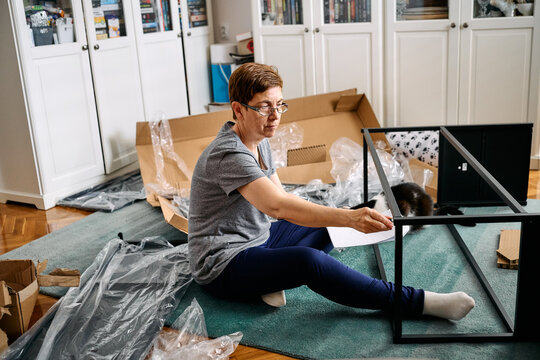Woman Assembling Flat Pack Furniture at Home