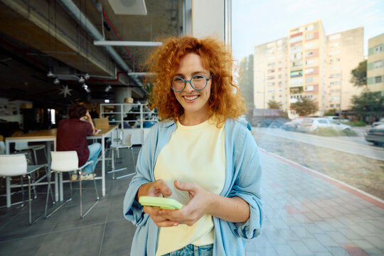 Young woman uses her mobile phone inside the university building