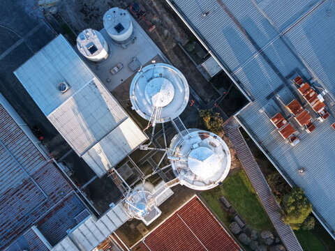 Ringwood, Australia - 10 September 2026: Aerial view of the Cadbury Mondelez factory featuring industrial silos, metal rooftops, and surrounding grounds in the late afternoon light.