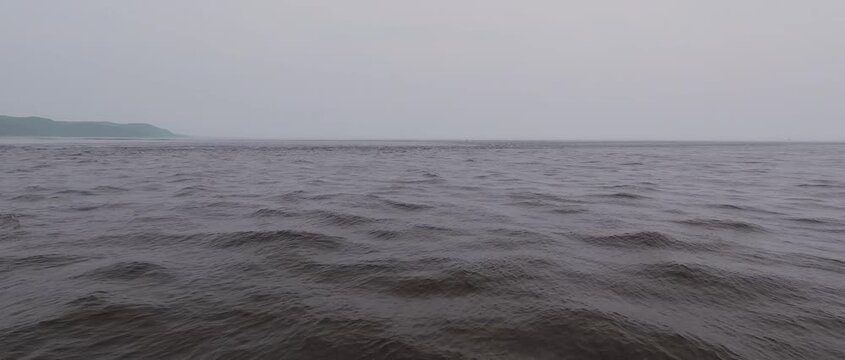 Dark choppy water and distant headland on St. Lawrence estuary
