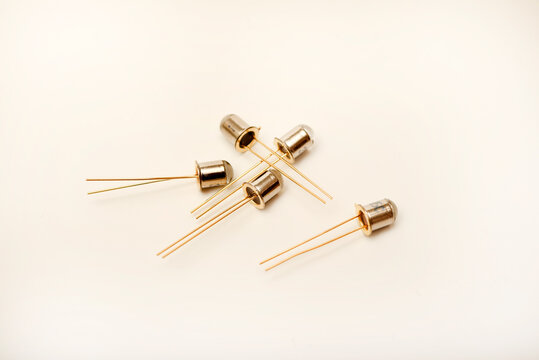 Metal photodiodes on a white background. Phototransistors. Yellow semiconductor devices.