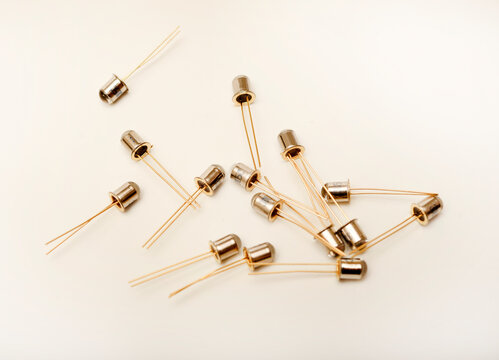 Metal photodiodes on a white background. Phototransistors. Yellow semiconductor devices.
