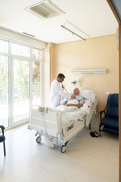 Doctor examining senior patient in hospital room
