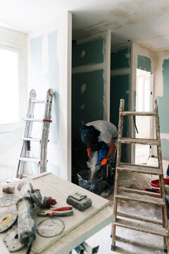 Worker preparing plaster in bucket
