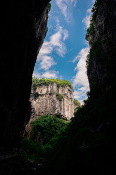 Narrow rock gap frames blue sky and cliffs in Wulong, China