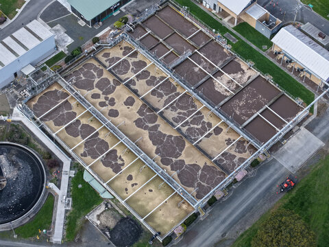 Lilydale, Australia - 10 September 2026: Aerial view of the Lilydale Wastewater Treatment Plant, featuring aeration tanks with bubbling water, industrial buildings, and green grass.