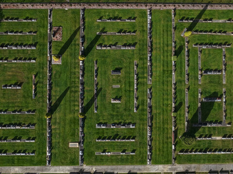 Ferntree Gully, Australia - 09 September 2026: Aerial view of Ferntree Gully Cemetery showing rows of graves, manicured green lawns, and long shadows cast by headstones in Victoria.