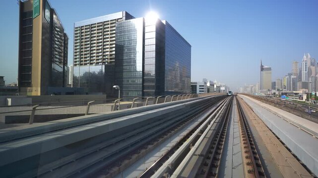 DUBAI, UAE - AUGUST 29, 2026: Dubai Metro train passes the camera in slow motion on an elevated railway beside Sheikh Zayed Road in Dubai UAE during daytime