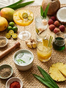 Fresh tropical fruit cocktails and exotic drinks served with lime pineapple and coconut on a table. Southeast Asian mocktails