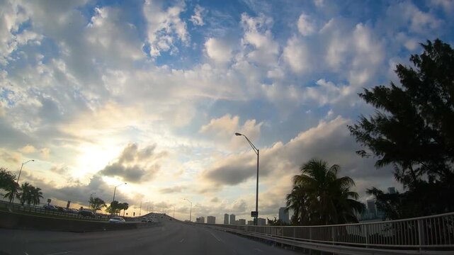 Driving toward Miami at dusk on a Florida freeway, with the fading evening light and dramatic clouds creating an atmospheric view of an American road trip.