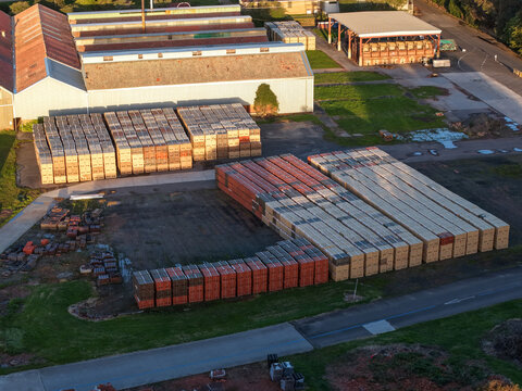 Melbourne, Australia - 07 September 2026: Aerial view of a tile manufacturing factory in Mitcham, featuring stacks of ceramic tiles stored in the yard next to industrial warehouse buildings.