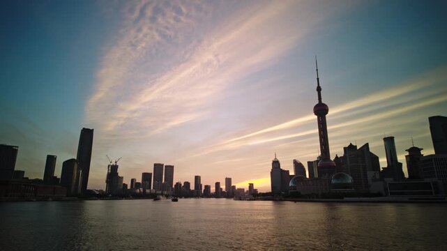 SHANGHAI, CHINA - AUGUST 23, 2026: Cirrus clouds drift across the dawn sky above the Pudong skyline and Huangpu River in SHANGHAI CHINA, in timelapse