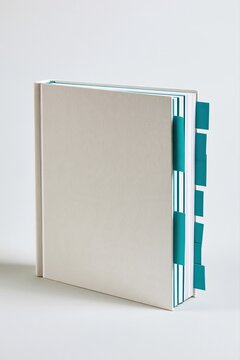 Livre reli&eacute; beige avec onglets turquoise color&eacute;s se tenant debout sur fond neutre