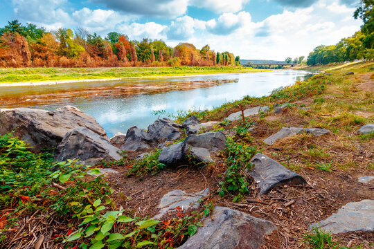 urban landscape with city park and a river in front. beautiful autumn scenery of Uzhhorod Orthodox embankment. vacation background with sky reflection on the water. fall season in Urkaine