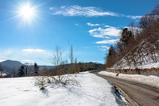 road through Carpathian mountain landscape in winter. travel countryside background. snow covered hills. sunny day