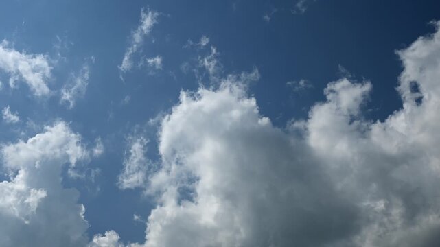 Timelapse of summer white cumulus clouds churning in a blue sky
