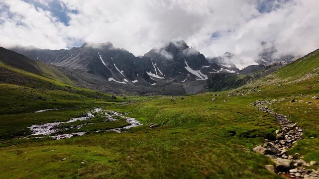 Forward aerial movement over green alpine mountain valley