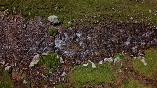 Overhead tracking shot of a shallow rocky stream