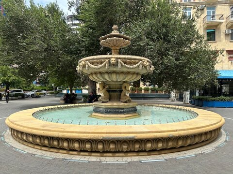 Antique fountain in the city park in summer.