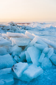 Large ice blocks of sea ice covering a frozen shoreline beneath a winter sky