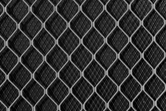 The focus is sharp on the foreground mesh, revealing the slight irregularities and industrial imperfections in the welds and wire thickness, while.