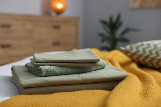 Home textile. Fresh clean linens and towel on bed indoors, closeup