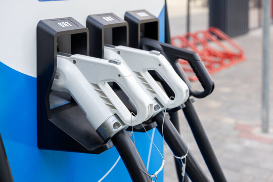 Electric vehicle charging guns at public parking station for accessible urban charging infrastructure