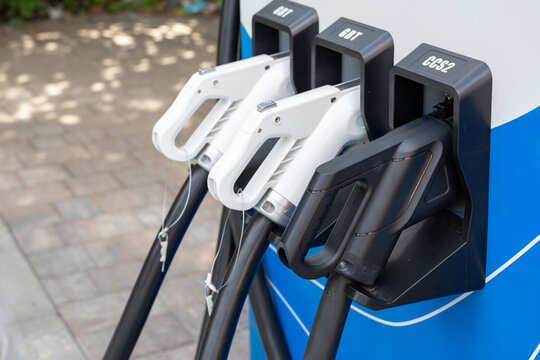 Electric vehicle charging guns for CCS2, GBT and CCS standards at outdoor charging station
