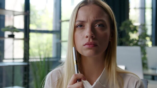 Puzzled confused pensive Caucasian business woman holding pen thinking difficult decision serious hesitating businesswoman hesitate office professional work solving working problem think girl female