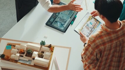Professional architect engineer sitting while explain house plan to manager. Aerial view of smart...