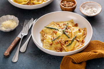 Pumpkin ravioli with brown butter and sage sauce served in bowls
