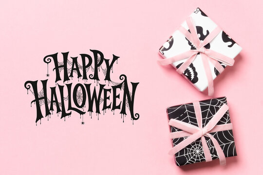 Happy Halloween lettering with black and white gift boxes, pink ribbons and spiderweb patterns on a pastel pink background, ideal for cards, invitations, posters and seasonal advertising.